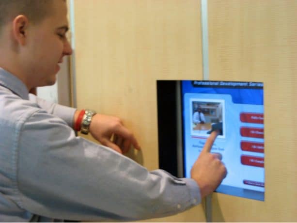 man using touch screen kiosk
