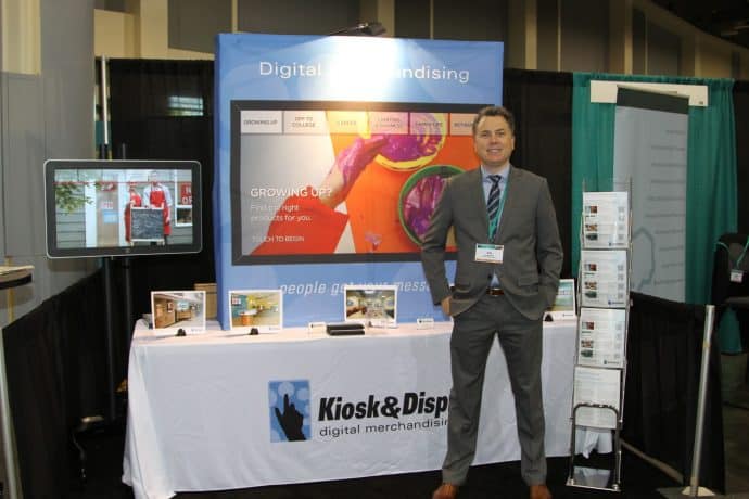 man standing in front of trade show booth