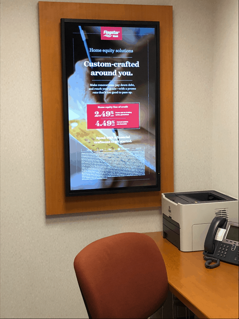 Flagstar Bank digital poster at customer service desk.